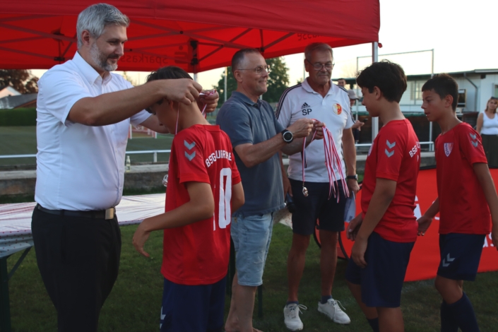 Sparkassen-Regionaldirektor Matthias Frank, TSV-Vorstandssprecher Thomas Schmideder und Sepp Perzl, Fußballabteilungsleiter Organisation, überreichten Medaillen an die D2-Junioren von der BSG Taufkirchen.